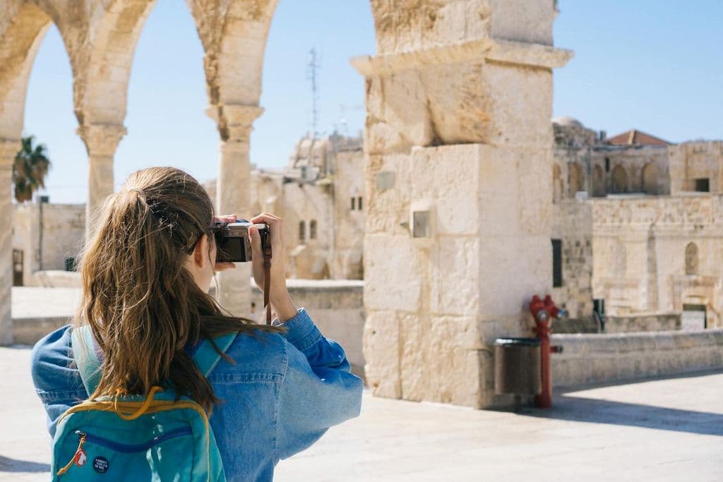 Una mujer fotografía ruinas.