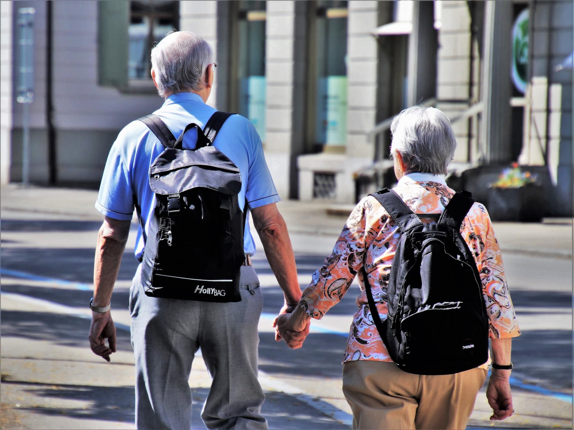 Una pareja de personas mayores caminando de la mano.