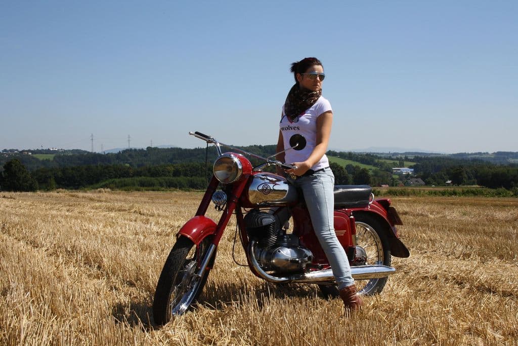 Una mujer en una moto en un campo.